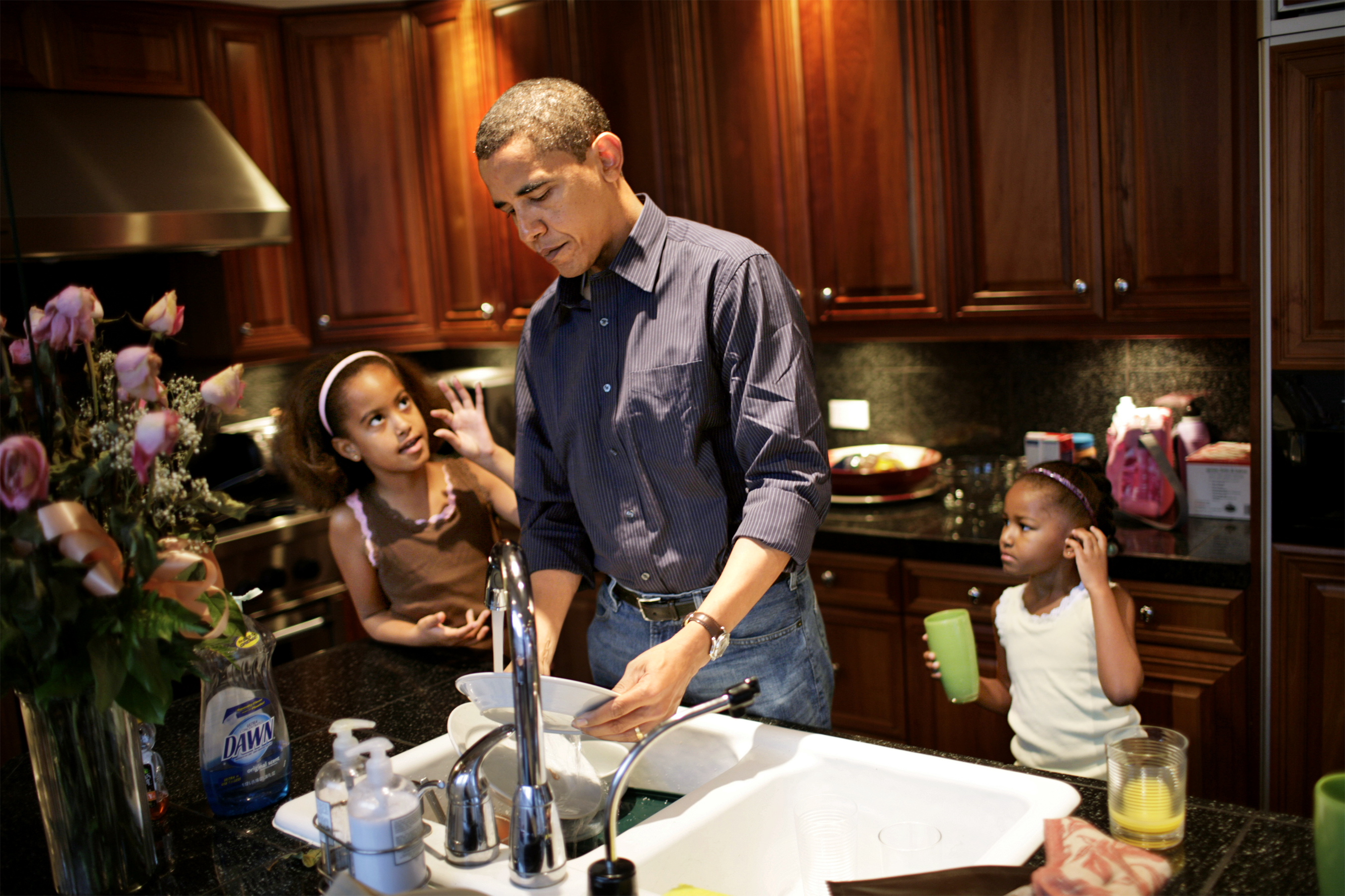 US Senator Barack Obama and his daughters (left) Malia, 8, and Sasha, 5, clean the dishes after breakfast at their home in Hyde Park - a suburb of Chicago, IL.  The girls were getting ready to go to school.
