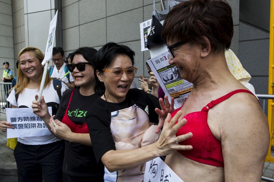 A protester (R) wears a bra during a demonstration in support of Hong Kong female protester Ng Lai-ying, outside the police headquarters in Hong Kong, China August 2, 2015. Ng was sentenced to three and a half months in jail for using her breast to bump against police at an anti-parallel trading protest, local media reported. REUTERS/Tyrone Siu
