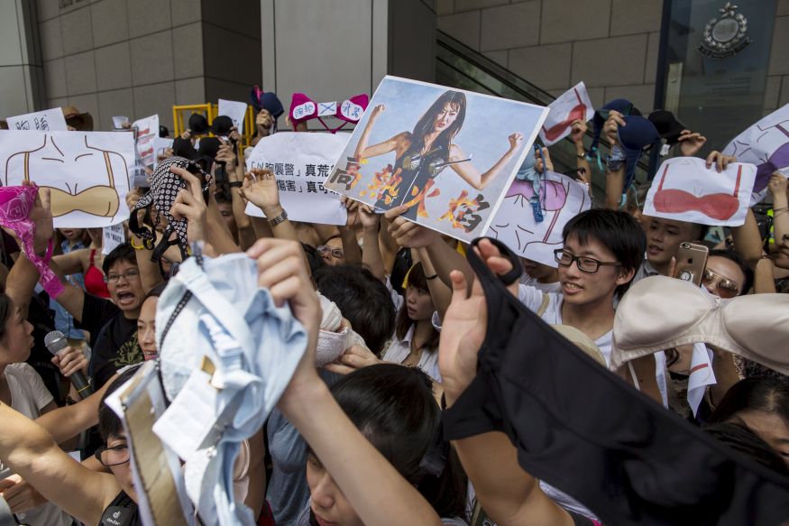 Protesters hold up bras during a demonstration in support of Hong Kong female protester Ng Lai-ying, outside the police headquarters in Hong Kong, China August 2, 2015. Ng was sentenced to three and a half months in jail for using her breast to bump against police at an anti-parallel trading protest, local media reported. REUTERS/Tyrone Siu